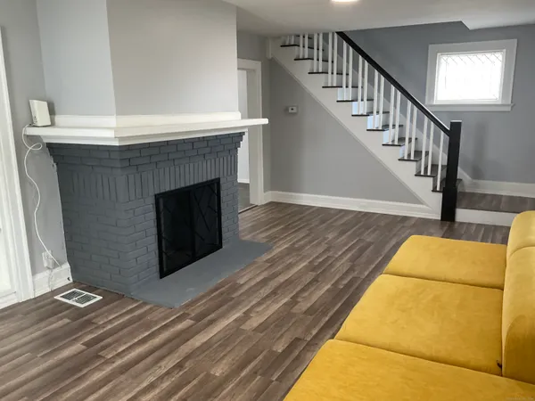 a living room with wooden floor and a fireplace