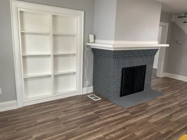 a room with a fireplace and a wooden floor