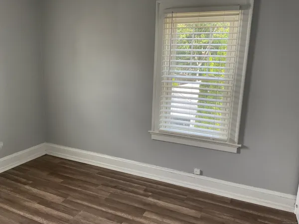 a view of a room that has wooden floor and a window