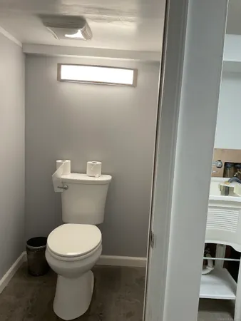 a white toilet sitting next to a white cabinet
