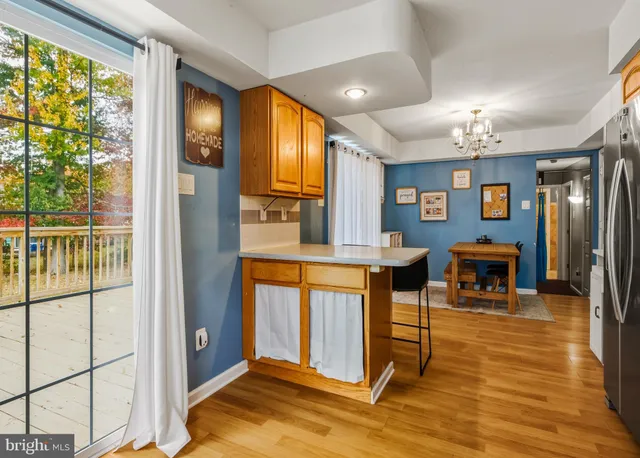 a view of a living room and kitchen with furniture wooden floor and windows
