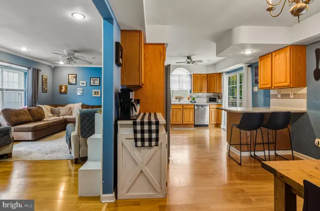 a living room with furniture a large window and wooden floor