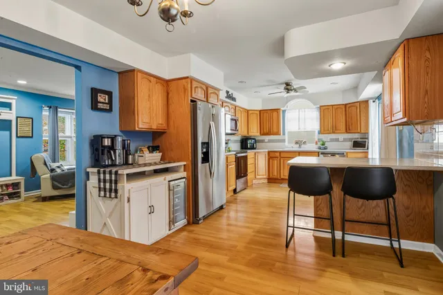 a kitchen with stainless steel appliances kitchen island granite countertop a refrigerator and a stove top oven