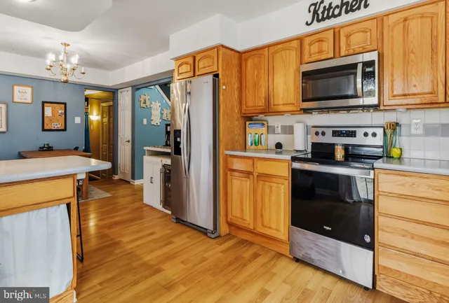 a kitchen with stainless steel appliances granite countertop wooden cabinets a stove top oven a sink and dishwasher