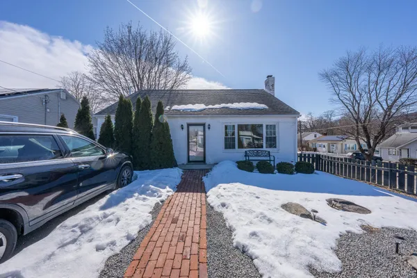a front view of a house with a yard covered in snow