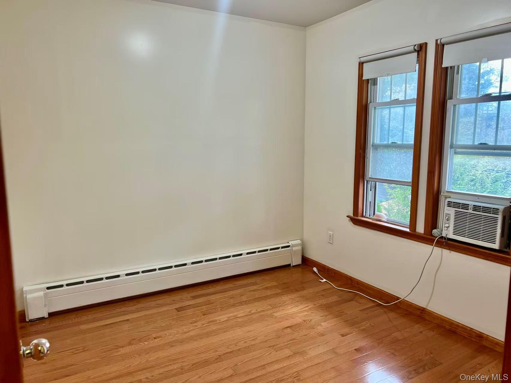 149-15 15th Road Queens, NY 11357 - Photo 13 of 20 an empty room with wooden floor and windows