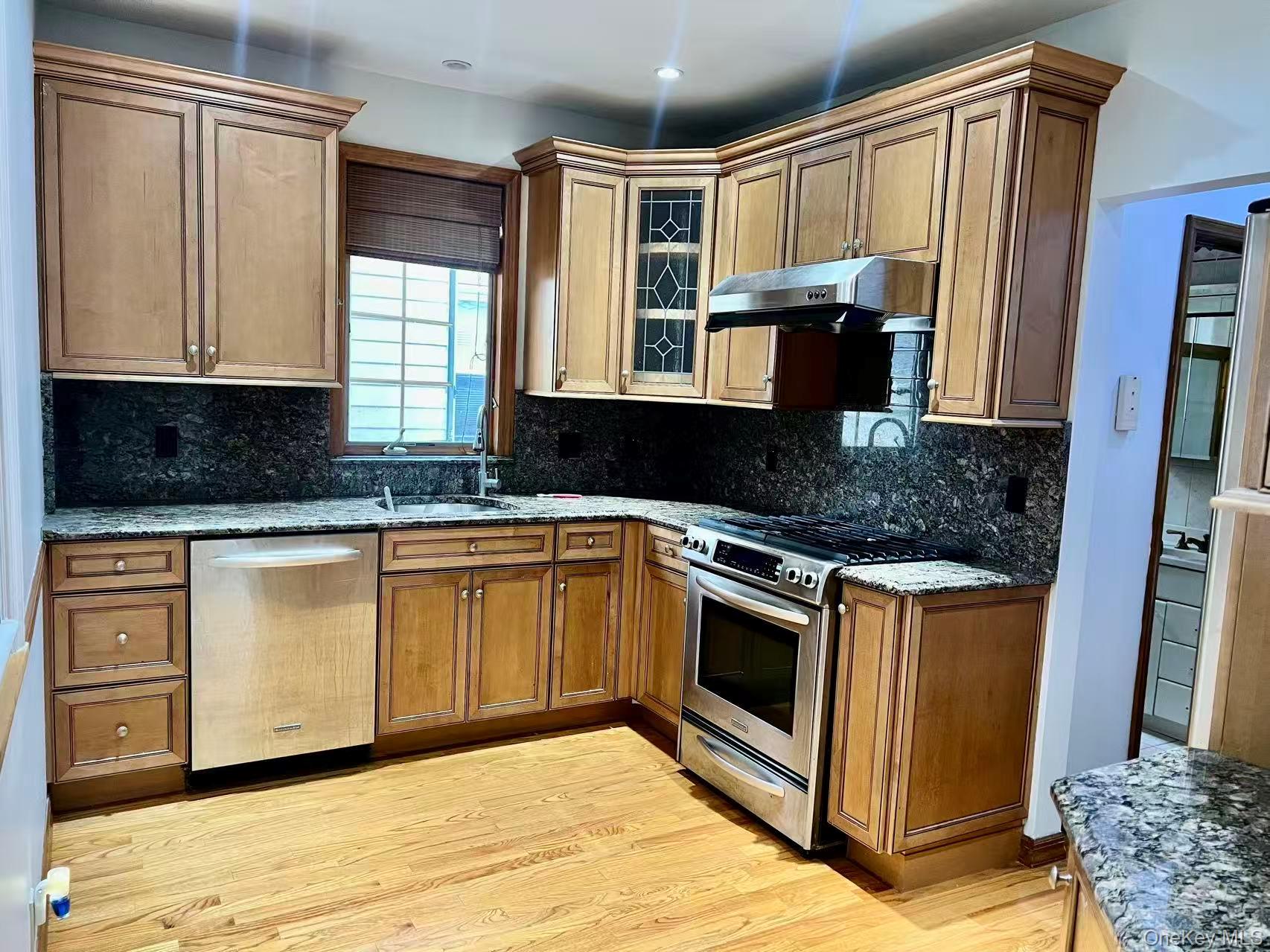 149-15 15th Road Queens, NY 11357 - Photo 4 of 20 a kitchen with stainless steel appliances granite countertop a stove a sink and a microwave
