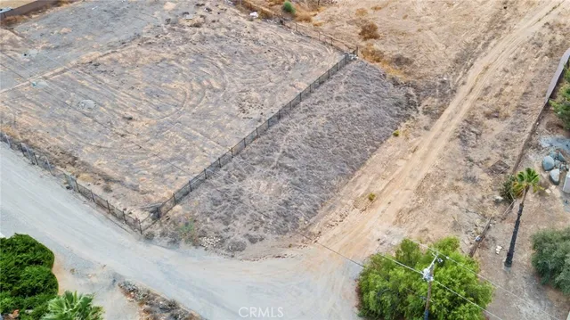 a view of a dry yard with trees