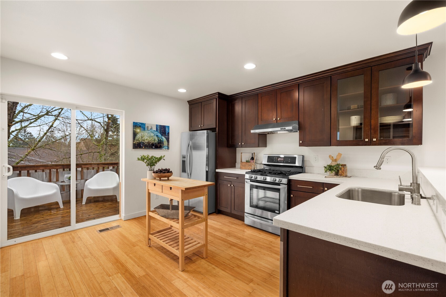 1029 Southwest 124th Street Burien, WA 98146 - Photo 11 of 40 a kitchen with granite countertop a stove top oven a sink dishwasher a dining table and chairs with wooden floor
