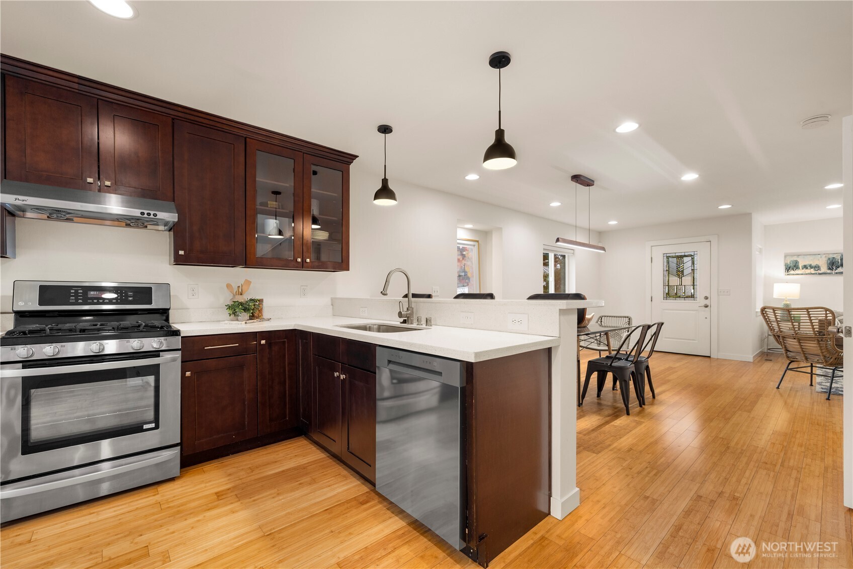 1029 Southwest 124th Street Burien, WA 98146 - Photo 12 of 40 a kitchen with stainless steel appliances granite countertop a sink a stove and a wooden floors