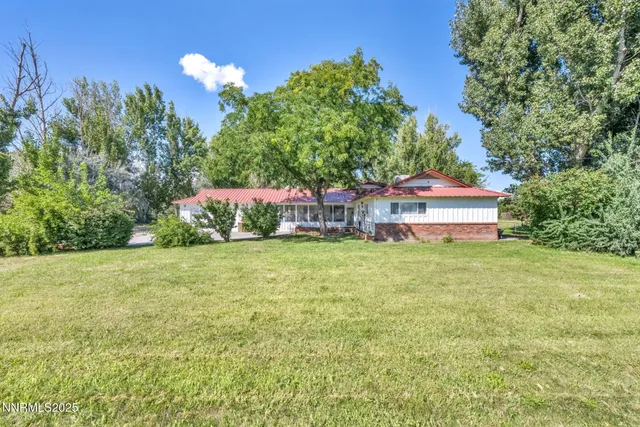 a view of a house with a backyard and basketball court