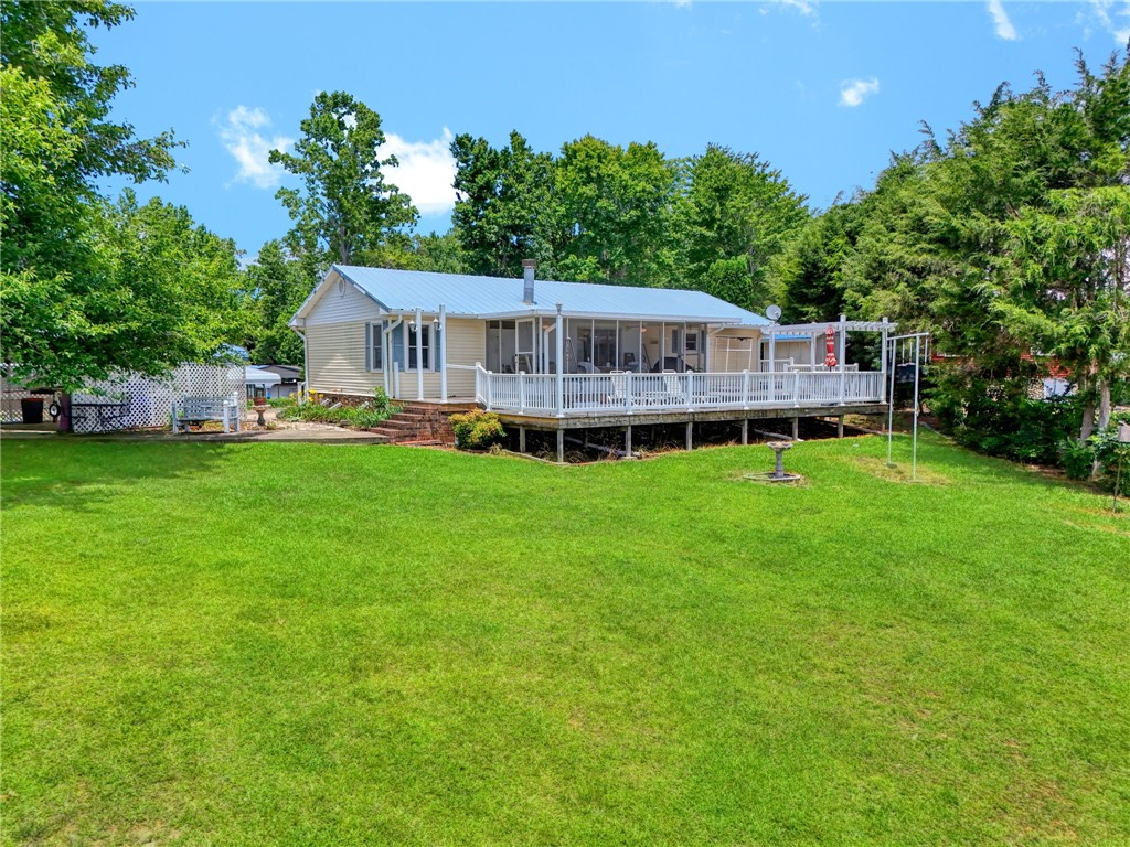 225 Nicholson Cove Road Seneca, SC 29672 - Photo 4 of 22 A broad, green lawn surrounds this home, featuring an elevated deck and screened porch.
