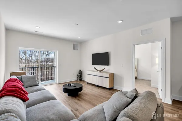 a living room with furniture a flat screen tv and a large window