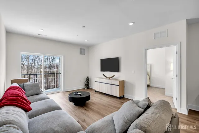 a living room with furniture a flat screen tv and a large window