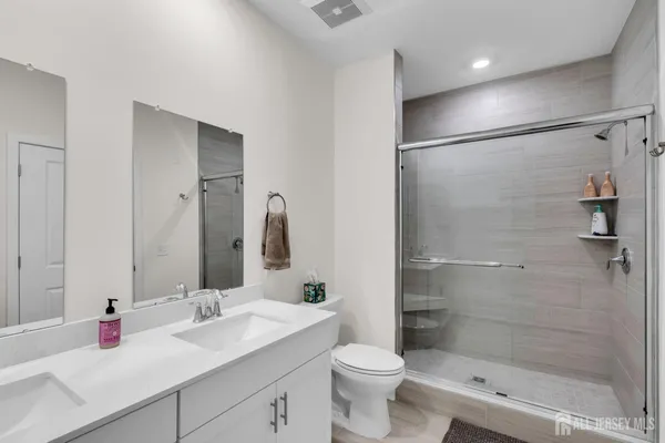 a bathroom with a double vanity sink toilet and shower
