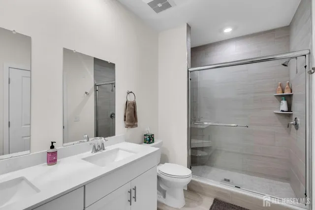 a bathroom with a double vanity sink toilet and shower