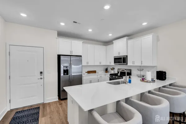 a kitchen with white cabinets and stainless steel appliances
