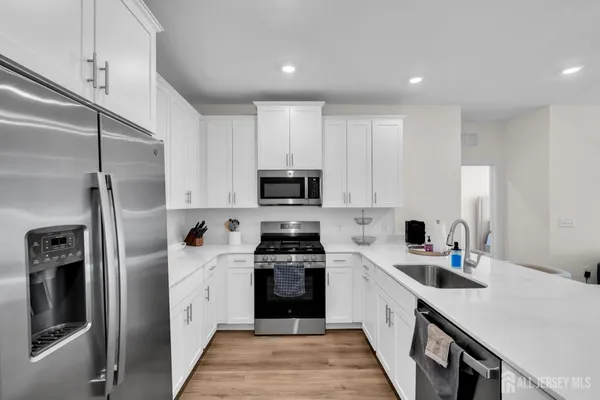a kitchen with white cabinets and stainless steel appliances