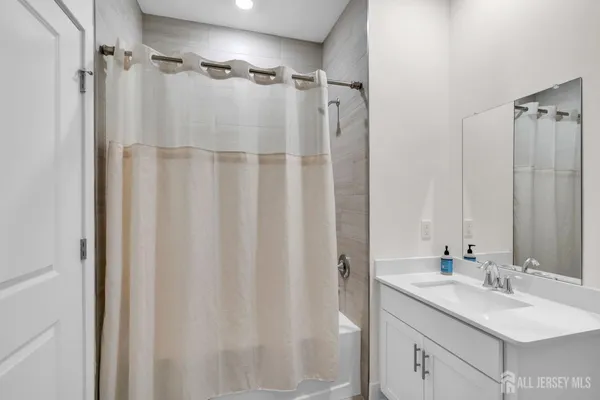a bathroom with a sink double vanity mirror and shower