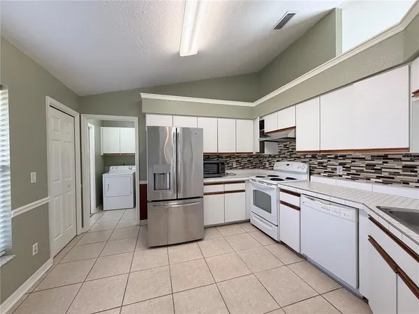 a kitchen with a stove top oven and white cabinets