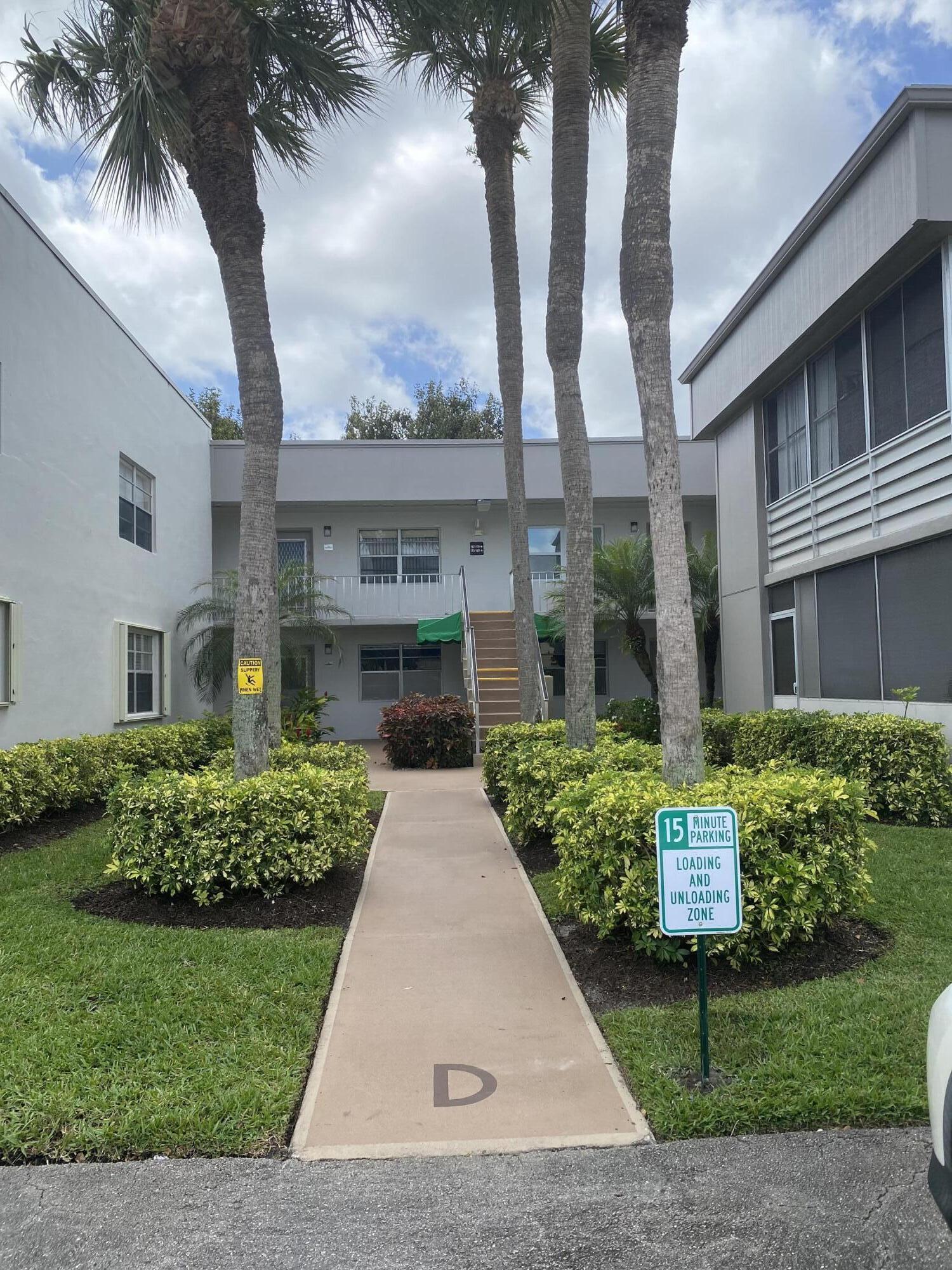 148 Normandy Lane Delray Beach, FL 33484 - Photo 12 of 29 front view of a house with a garden