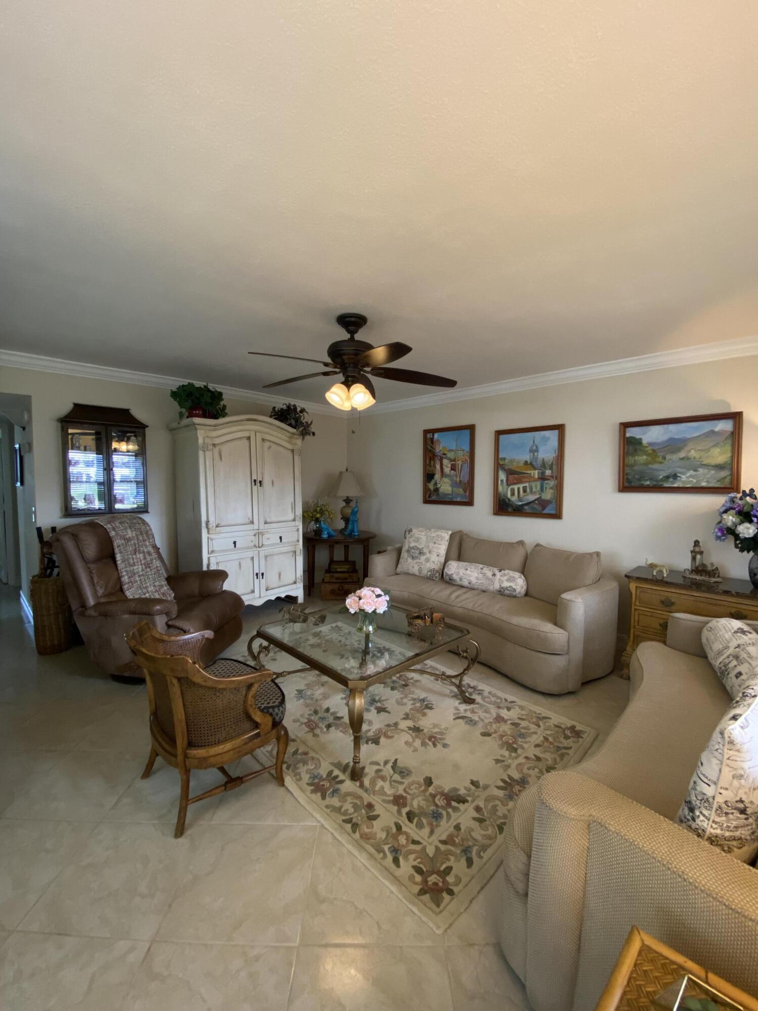 148 Normandy Lane Delray Beach, FL 33484 - Photo 2 of 29 a living room with furniture and a chandelier