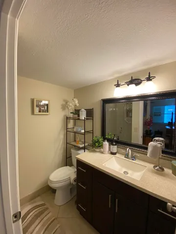 a bathroom with a double vanity sink toilet and mirror