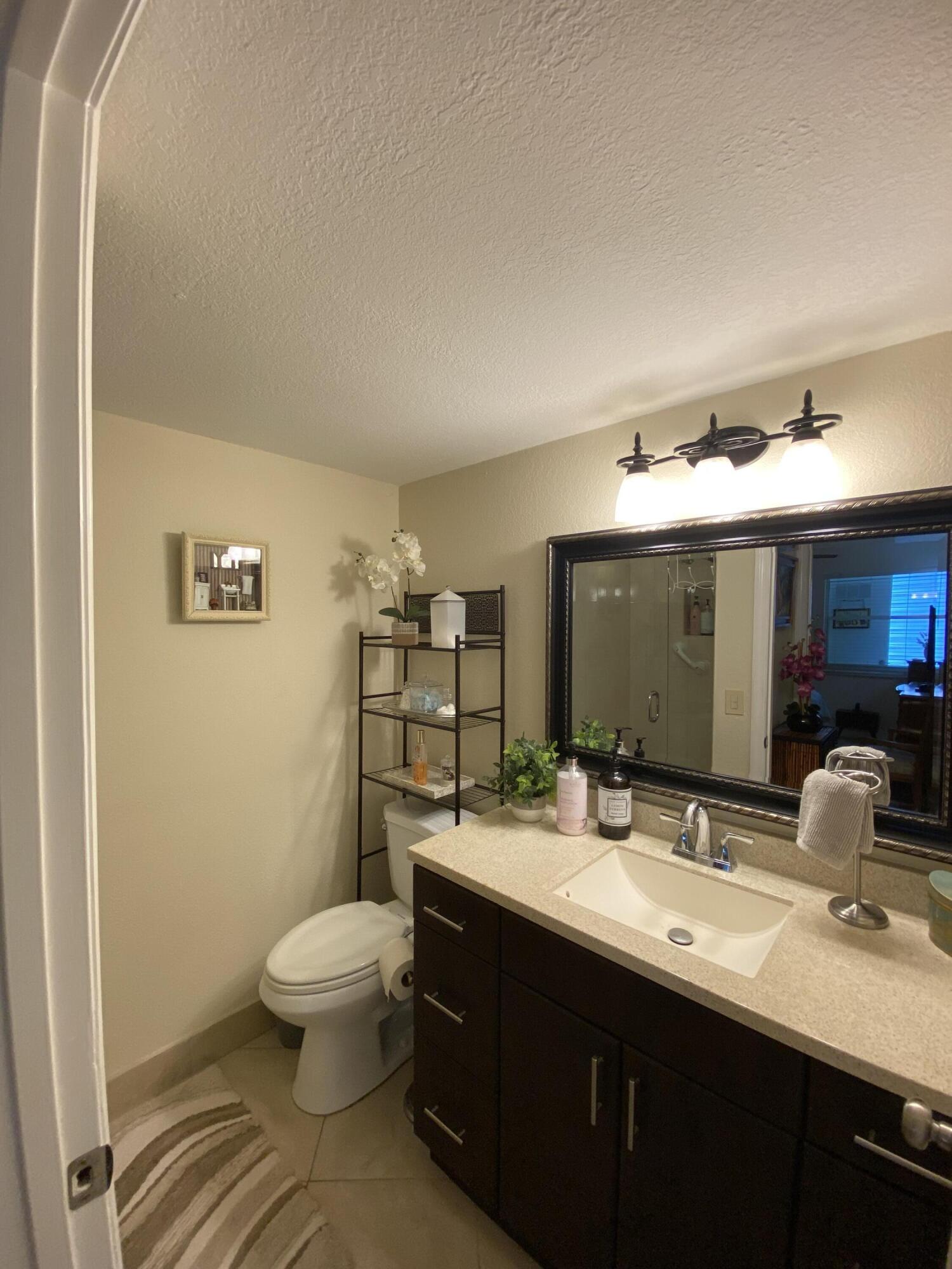 148 Normandy Lane Delray Beach, FL 33484 - Photo 28 of 29 a bathroom with a double vanity sink toilet and mirror