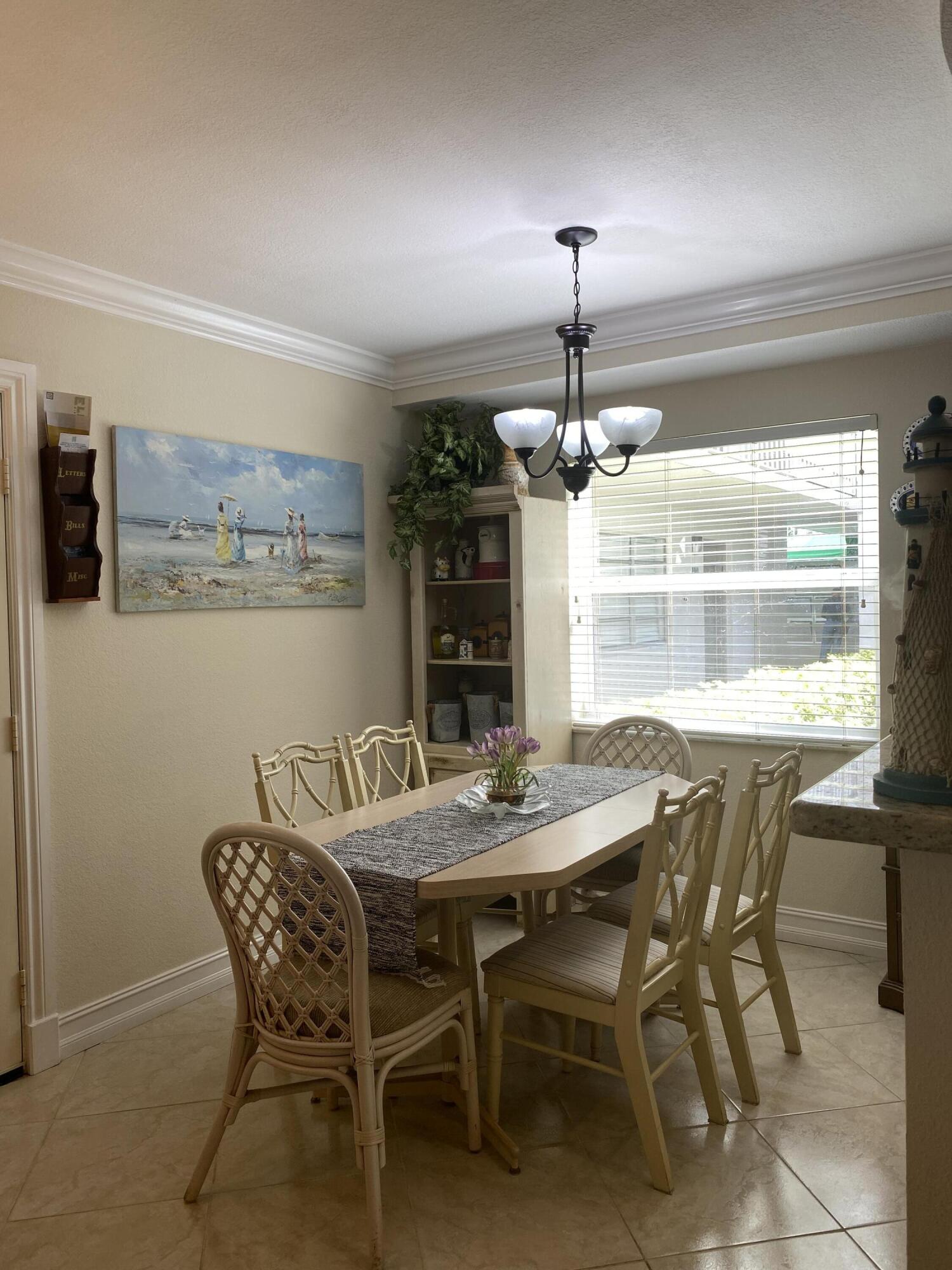 148 Normandy Lane Delray Beach, FL 33484 - Photo 5 of 29 a dining room with a wooden table and chairs