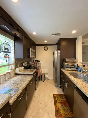 a large kitchen with a large counter top sink stove and refrigerator