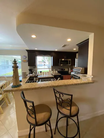 a kitchen with stainless steel appliances kitchen island granite countertop a sink and cabinets