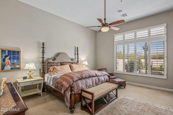 a bedroom with a bed a chandelier and a window