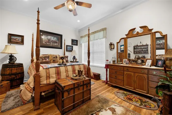 a bedroom with a bed a flat screen tv and windows