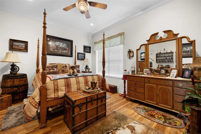 a bedroom with a bed a flat screen tv and windows