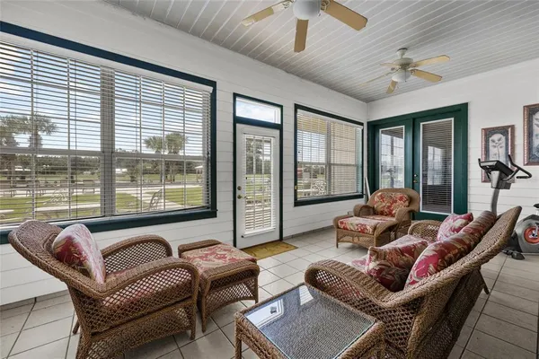 a dining hall with stainless steel appliances kitchen island granite countertop a table chairs and a large window