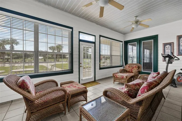 a dining hall with stainless steel appliances kitchen island granite countertop a table chairs and a large window