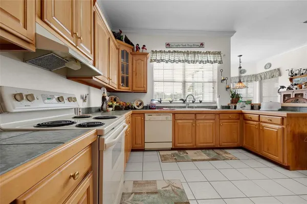 a kitchen with stainless steel appliances kitchen island granite countertop a refrigerator and a sink