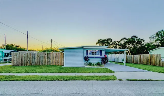 a front view of a house with a yard and fence