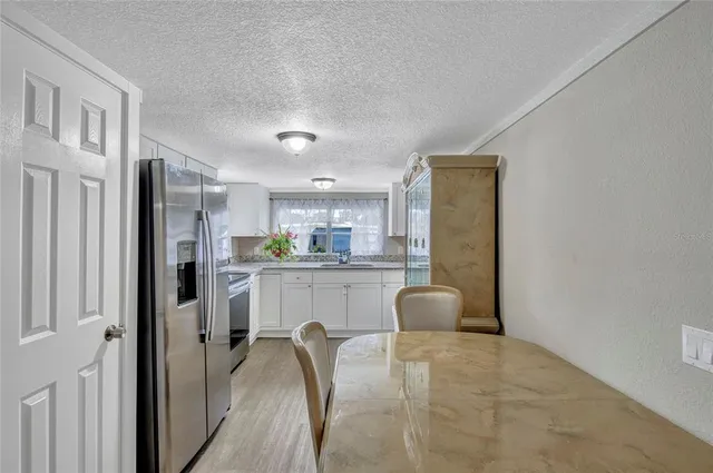 a kitchen with refrigerator cabinets and chair