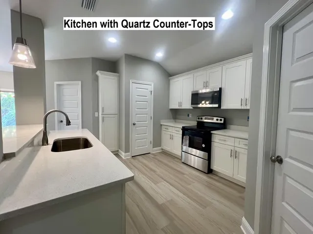 a kitchen with a sink cabinets and wooden floor
