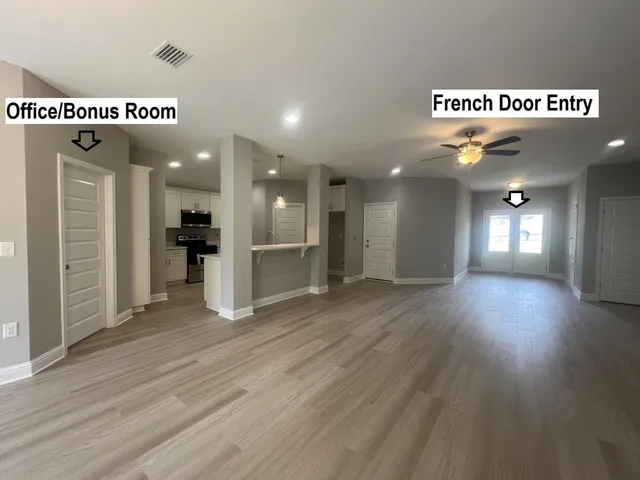 an empty room with wooden floor and windows