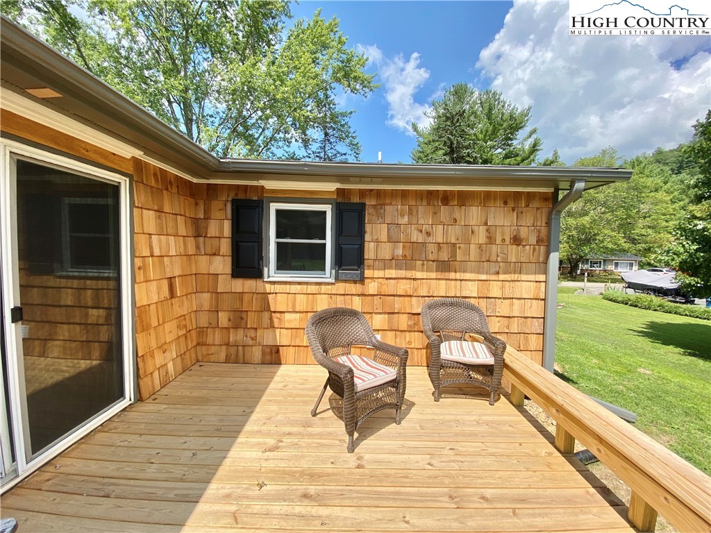 272 Clint Lewis Road Boone, NC 28607 - Photo 18 of 32 a view of a patio with table and chairs with wooden floor and fence