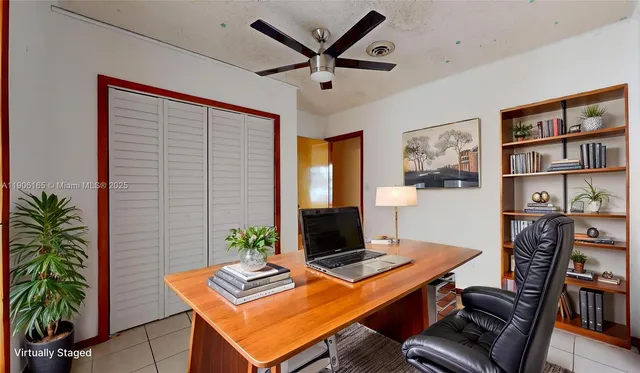 a view of a livingroom with a chandelier fan and windows