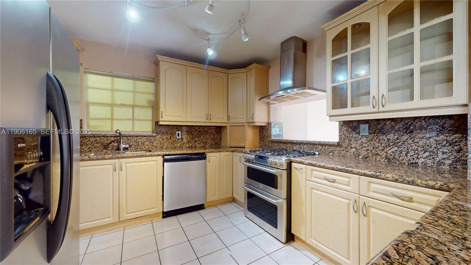 6051 Southwest 110th Avenue Miami, FL 33173 - Photo 10 of 49 a kitchen with stainless steel appliances granite countertop a stove sink and cabinets