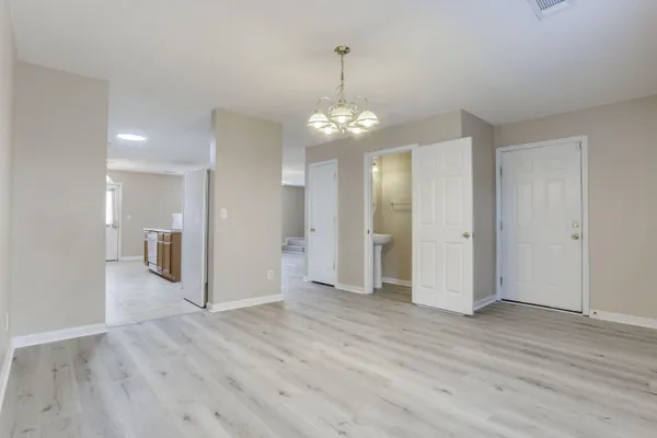 an empty room with wooden floor and mirror