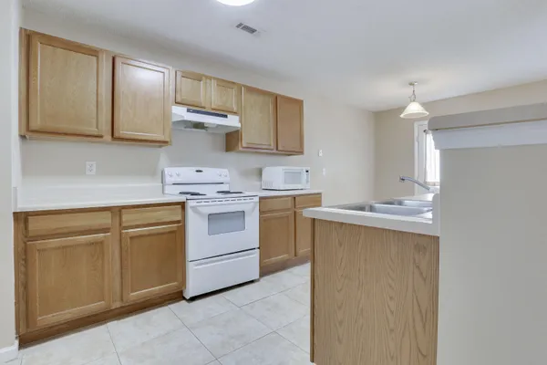 a kitchen with a sink a stove and cabinets