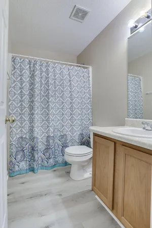 a bathroom with a granite countertop toilet and a sink