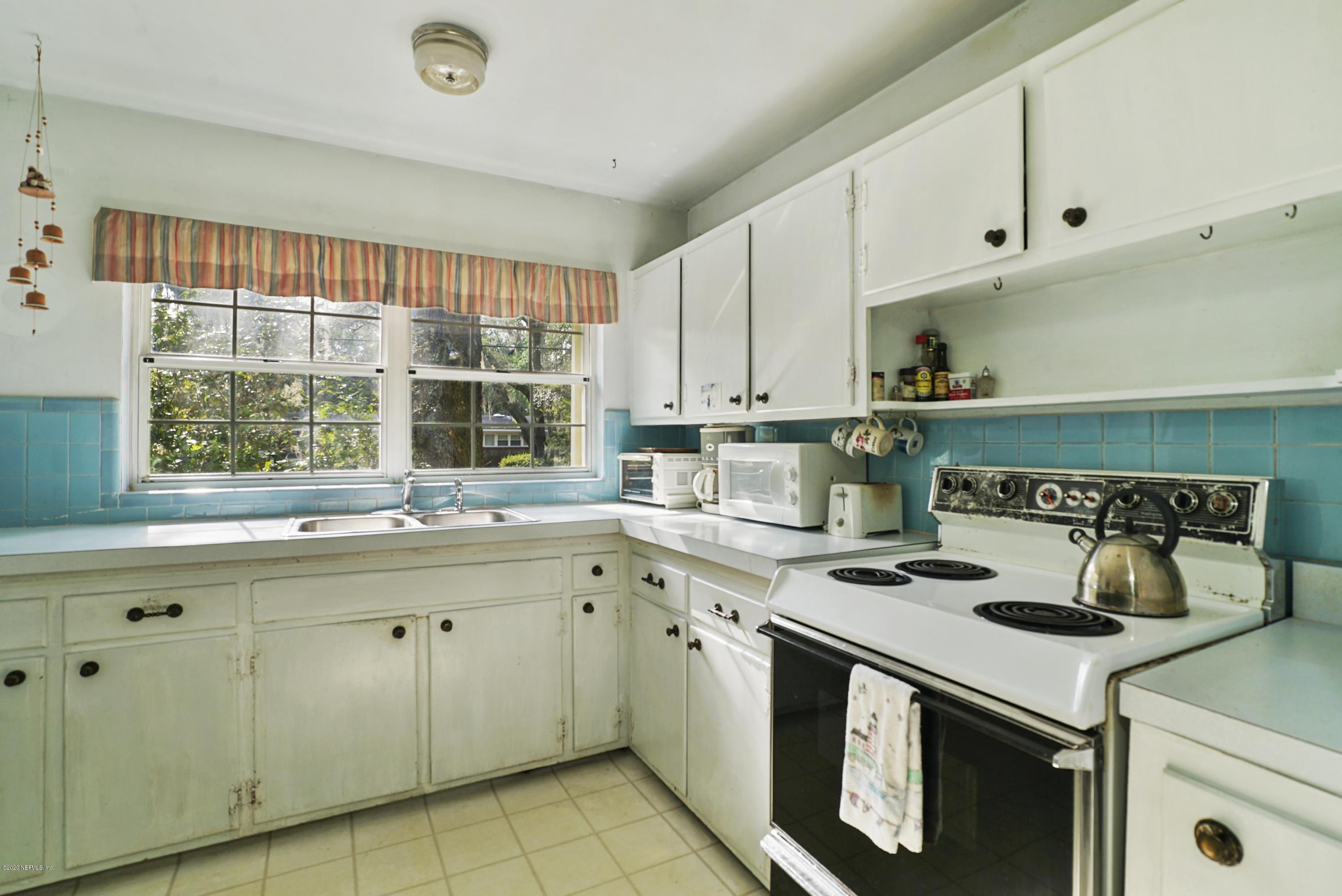 2531 Elbow Road Orange Park, FL 32073 - Photo 3 of 30 a kitchen with a stove and white cabinets
