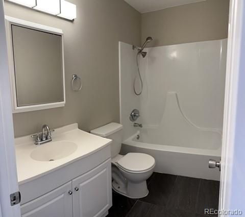 1976 Eagle Street Aurora, CO 80011 - Photo 14 of 14 a bathroom with a white toilet sitting next to a bathroom sink and a shower
