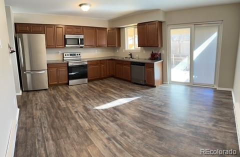 1976 Eagle Street Aurora, CO 80011 - Photo 2 of 14 a kitchen with stainless steel appliances granite countertop a stove a sink and a refrigerator
